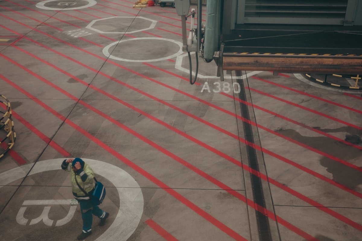 Worker directing an airplane on an airport tarmac.