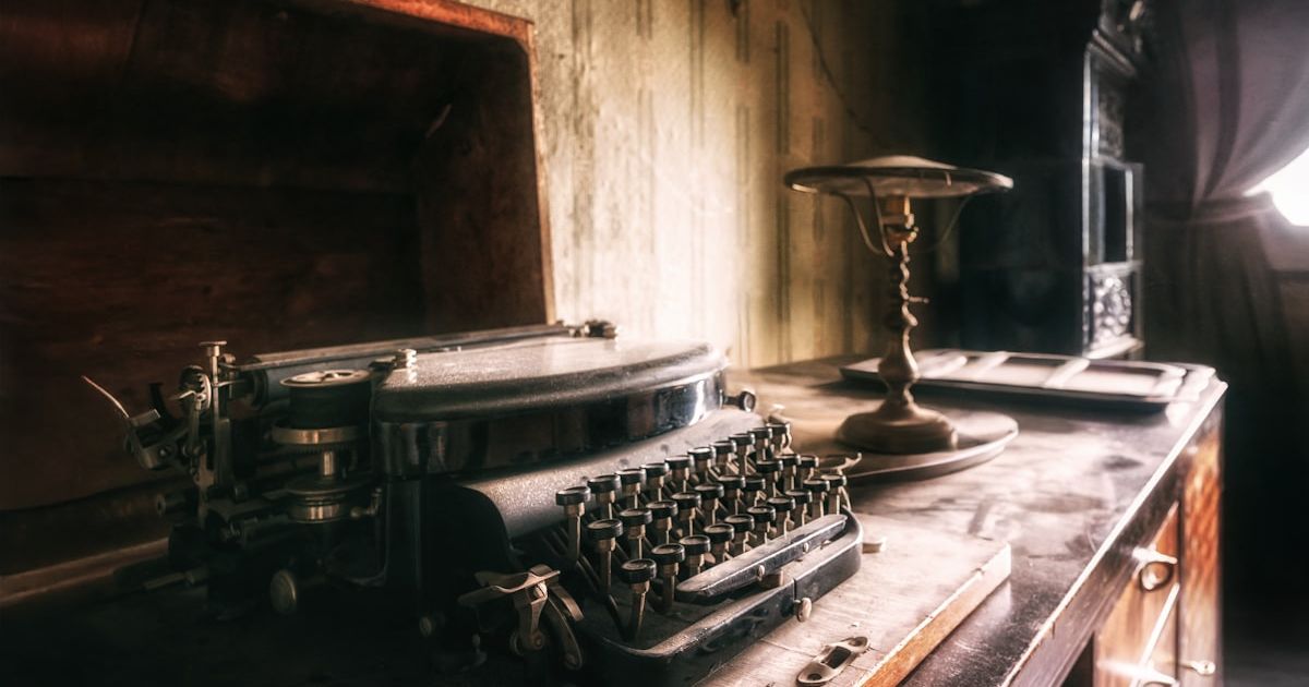 Antique typewriter on a dusty wooden desk.