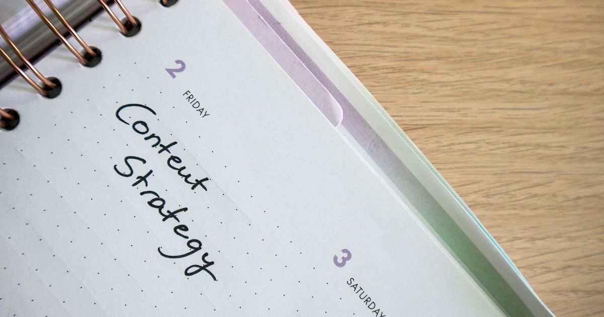 a spiral notebook with a notepad and pen on top of it