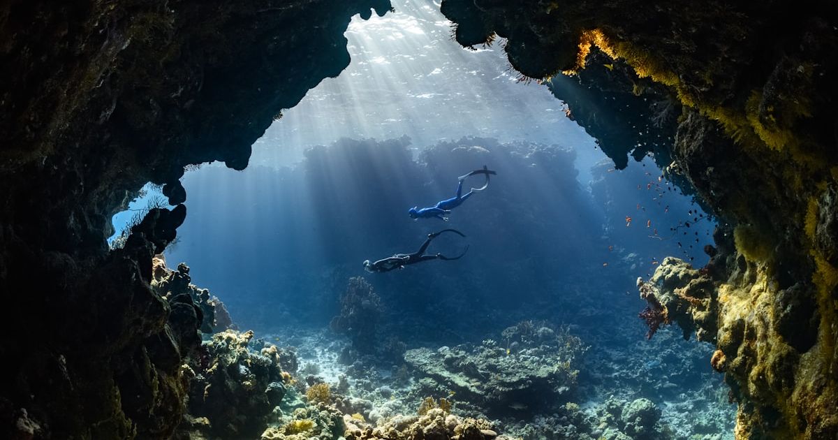 a scuba diver swims through an underwater cave